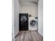 Laundry room featuring a black washing machine and a white dryer at 12798 Ivy St, Thornton, CO 80602
