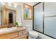 Bright bathroom features a shower over tub, wood vanity and a window view to outside at 19050 Archers Dr, Monument, CO 80132