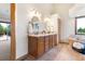 Bathroom featuring a double vanity, wood cabinets and drawers, marble counters, and views at 19050 Archers Dr, Monument, CO 80132