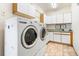 Functional laundry room with cabinets and countertops, washer, and dryer on tile flooring at 19050 Archers Dr, Monument, CO 80132
