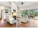 Bright living room with fireplace, built-in shelving, hardwood floors, and access to the deck at 19050 Archers Dr, Monument, CO 80132