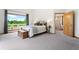 Bright bedroom with large windows and view, with ensuite bathroom, and carpeted floors at 19050 Archers Dr, Monument, CO 80132