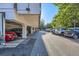 Well-maintained covered parking area with clearly marked spaces and mature trees at 937 N Clarkson St # 206, Denver, CO 80218