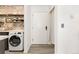 Kitchen with brick accent wall, washer/dryer and open access to the front door at 3035 Oneal Pkwy # 36T, Boulder, CO 80301