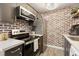 Stylish kitchen features stainless steel appliances, brick accent wall, and ample cabinet space at 3035 Oneal Pkwy # 36T, Boulder, CO 80301