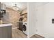 Charming kitchen boasts a brick accent wall, floating shelves, and stainless steel appliances at 3035 Oneal Pkwy # 36T, Boulder, CO 80301