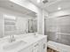 Bathroom featuring double sink vanity with white cabinets and a glass-enclosed shower at 22435 E 7Th Pl, Aurora, CO 80018