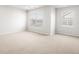 Bright bedroom featuring neutral carpet, two windows offering natural light, and fresh white walls at 22435 E 7Th Pl, Aurora, CO 80018