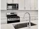 Modern kitchen with stainless steel gas range and faucet, against a white backsplash at 22435 E 7Th Pl, Aurora, CO 80018