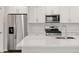 Open concept kitchen with stainless steel appliances and white cabinets at 22435 E 7Th Pl, Aurora, CO 80018