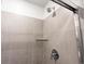 Close-up of shower with tile surround, glass shelf, and modern fixtures at 22435 E 7Th Pl, Aurora, CO 80018