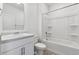 Clean bathroom with white vanity, toilet, and shower/tub with shelves, all brightly lit at 4730 Hatcher Dr, Brighton, CO 80601