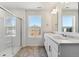 Bright bathroom with glass enclosed shower, double sinks, and a large mirror at 4730 Hatcher Dr, Brighton, CO 80601