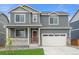 Charming two-story home with gray siding, stone accents, a covered porch and a two car garage at 4730 Hatcher Dr, Brighton, CO 80601