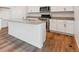 Kitchen island with granite countertops, stainless steel sink, stainless steel appliances, and wood-style flooring at 4730 Hatcher Dr, Brighton, CO 80601