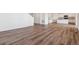 Open-concept living space with wood-style flooring, leading to the stairs and a view of the kitchen at 4730 Hatcher Dr, Brighton, CO 80601