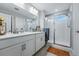 Bright bathroom featuring a double vanity and glass shower door at 8470 Arriba Dr, Littleton, CO 80125