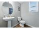 Powder room featuring a pedestal sink, oval mirror, and wood-look floors at 8470 Arriba Dr, Littleton, CO 80125