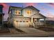 Charming two-story home featuring stone accents, a covered porch, and a two-car garage at dusk at 8470 Arriba Dr, Littleton, CO 80125