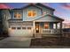 Two-story home featuring an attached garage, welcoming front porch, and classic architectural design at 8470 Arriba Dr, Littleton, CO 80125