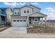 Charming two-story home featuring stone accents, a covered porch, and a two-car garage at 8470 Arriba Dr, Littleton, CO 80125