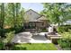 Private backyard featuring patio, firepit, manicured green lawn and mature landscaping at 628 Cherry St, Denver, CO 80220