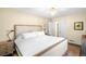 Bright bedroom features a neutral palette, chandelier, and a large upholstered bed with white linens at 628 Cherry St, Denver, CO 80220