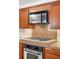 Kitchen with stainless steel oven and cooktop, wood cabinets, and tile backsplash for a functional cooking space at 628 Cherry St, Denver, CO 80220