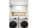 Bright laundry room with modern washer and dryer and ample overhead storage at 628 Cherry St, Denver, CO 80220