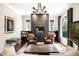 Stylish living room with modern fireplace, leather chairs, and large windows providing natural light and outdoor views at 628 Cherry St, Denver, CO 80220
