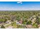 Wide aerial view showcasing the property amidst a lush, tree-filled neighborhood and distant skyline at 7340 W 32Nd Ave, Wheat Ridge, CO 80033