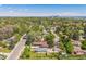 Scenic aerial shot of the property nestled in a green neighborhood with mature trees and skyline in the distance at 7340 W 32Nd Ave, Wheat Ridge, CO 80033