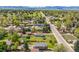 Expansive aerial shot of the property featuring a spacious yard, surrounding trees, and neighborhood layout at 7340 W 32Nd Ave, Wheat Ridge, CO 80033