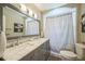 Bathroom with a double vanity, marble countertop, and shower with a curtain at 7340 W 32Nd Ave, Wheat Ridge, CO 80033