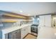 Bright kitchen with stainless steel appliances, open shelving and white cabinets at 7340 W 32Nd Ave, Wheat Ridge, CO 80033