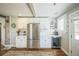 Bright kitchen with stainless steel appliances, white cabinets, beverage cooler, and wood floors at 7340 W 32Nd Ave, Wheat Ridge, CO 80033