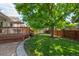 Backyard featuring a lush lawn, spacious deck, and mature trees providing ample shade at 6134 W 83Rd Way, Arvada, CO 80003