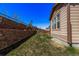 A landscaped backyard with a retaining wall, terraced slope, and windmill decoration at 7514 Blue Water Dr, Castle Rock, CO 80108