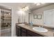 Bathroom featuring double sinks with dark wood cabinets, a large mirror, and a tub at 7514 Blue Water Dr, Castle Rock, CO 80108
