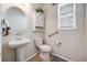 Well-lit half bathroom with a pedestal sink and decorative cabinet at 7514 Blue Water Dr, Castle Rock, CO 80108