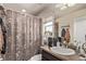 Bathroom features a mirror, vanity, sink, and shower with a floral shower curtain at 7514 Blue Water Dr, Castle Rock, CO 80108