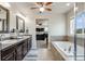 Elegant bathroom featuring dual sink vanity, soaking tub, and tile flooring with a view to the bedroom at 7514 Blue Water Dr, Castle Rock, CO 80108