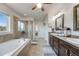 Bright bathroom showcasing a dual sink vanity, soaking tub, and glass shower, perfect for relaxation and convenience at 7514 Blue Water Dr, Castle Rock, CO 80108