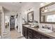 Well-lit bathroom featuring double sinks, a vanity, and a walk-in closet at 7514 Blue Water Dr, Castle Rock, CO 80108