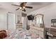 Bright bedroom with carpet, drawers, mirrors and ceiling fan with decorative light at 7514 Blue Water Dr, Castle Rock, CO 80108