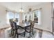 Bright dining room featuring a large table, elegant chairs, hardwood floors and multiple windows at 7514 Blue Water Dr, Castle Rock, CO 80108