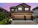 Charming two-story home featuring a three-car garage and landscaped front yard at dusk at 7514 Blue Water Dr, Castle Rock, CO 80108