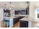 Spacious kitchen features dark cabinetry, granite counters, stainless steel appliances, and large central island with bar seating at 7514 Blue Water Dr, Castle Rock, CO 80108