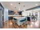 Spacious kitchen with dark cabinetry, a center island with seating, and modern lighting at 7514 Blue Water Dr, Castle Rock, CO 80108