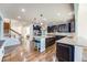 Open-concept kitchen with a large island, dark wood cabinets, and hardwood floors at 7514 Blue Water Dr, Castle Rock, CO 80108